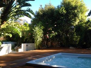 een hot tub in het midden van een tuin met bomen bij Ocean Lounge in Kaapstad