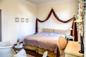 a bedroom with a bed and a table and chairs at Hotel Zum Bär in Quedlinburg