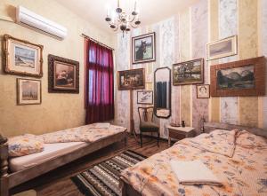 1 dormitorio con 2 camas y cuadros en las paredes en Guest House Malkia Inter, en Veliko Tŭrnovo