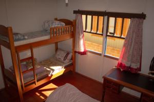 ein Zimmer mit zwei Etagenbetten und einem Schreibtisch in der Unterkunft Nossa casa em Canela in Canela