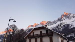 una casa con una montaña cubierta de nieve en el fondo en Appartement Native en Chamonix-Mont-Blanc