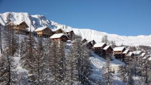 een resort in de bergen bedekt met sneeuw bij Boost Your Immo Chalet des Rennes 83 in Vars
