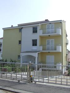 a building with a fence in front of it at Apartments Renato in Zadar