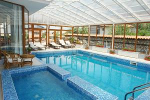 a large swimming pool with chairs at Elegant Hotel in Bansko