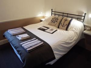 1 cama con 2 toallas plegables encima en Andora Guest House, en Southport