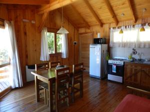 a kitchen with a table and chairs and a refrigerator at Casita de Madera in San Carlos de Bariloche