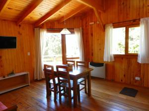 comedor con mesa de madera y sillas en Casita de Madera en San Carlos de Bariloche