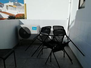 three chairs and a table on a balcony at Lagos City Center Guest House & Hostel in Lagos