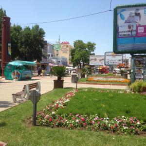 a park in a city with flowers and a tv at Hotel Atol in Sunny Beach