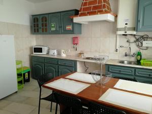 uma cozinha com armários verdes e uma mesa com cadeiras em Lagos City Center Guest House & Hostel em Lagos
