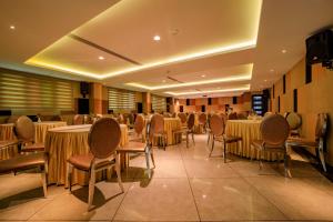 a banquet hall with tables and chairs in a room at Ambara Suites in Trivandrum