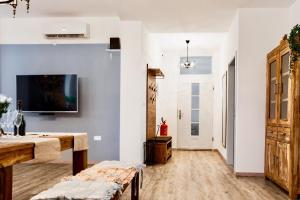 a living room with a table and a tv on a wall at Happy Casa Oldtown Boutique in Koper