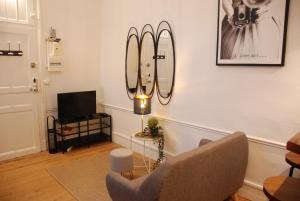 - un salon avec une chaise et une télévision dans l'établissement Le typique - coeur de ville, à Toulouse
