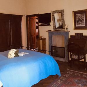 a bedroom with a blue bed and a fireplace at SPINETO HOUSE in Spineto Scrivia