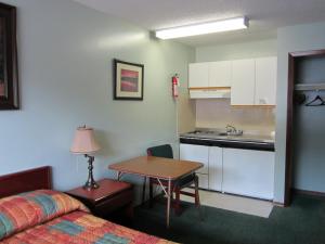 Habitación con cama, mesa y cocina. en Aleeda Motel, en Prince Rupert