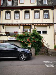 ein schwarzes Auto, das vor einem Gebäude parkt in der Unterkunft Pension am Rheinsteig in Leutesdorf
