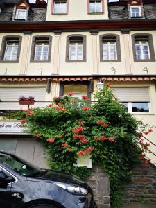 un edificio con flores rojas a un lado. en Pension am Rheinsteig, en Leutesdorf