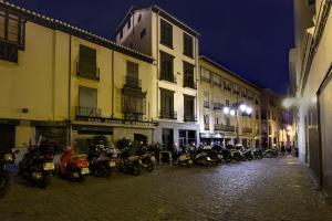 a group of motorcycles parked on a street at night at Imeda Apartamentos Escudo del Carmen 19 in Granada