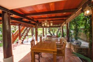 an outdoor dining room with a wooden table and chairs at Phuttal Residence in Phra Nakhon Si Ayutthaya