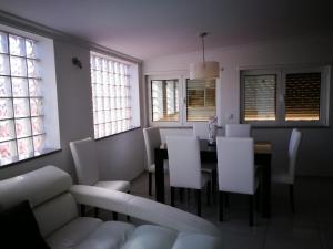 a dining room with a table and white chairs at Casa do Ti Correia in Macedo de Cavaleiros