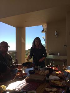 a woman standing in front of a table with food at Windhoek Rural Self Catering in Voigtland