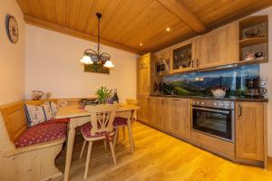 uma cozinha com uma mesa e uma sala de jantar em Ferienwohnung Sonnenhäusl em Mittenwald