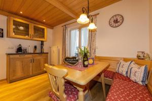 uma cozinha com uma mesa de madeira e uma sala de jantar em Ferienwohnung Sonnenhäusl em Mittenwald