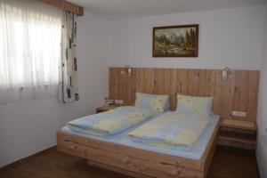 a bedroom with a bed with a wooden headboard at Bahlerhof - Luxner Annelies in Ried im Zillertal