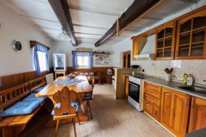 a kitchen with a wooden table and a dining room at Chaloupka u potoka in Svetla Hora