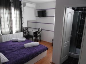 1 dormitorio con 1 cama morada y 2 toallas en Prenociste Bojan 017, en Vranje 95 fotos más