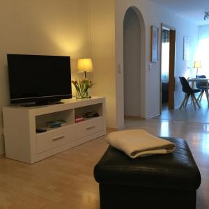 a living room with a flat screen tv and a stool at Appartement 29/1 in Schwäbisch Hall