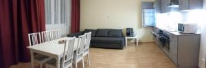 a living room with a couch and a table and a kitchen at Apartment nahe Rosenhügel in Vienna