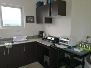 cocina con armarios negros y encimera con microondas en Playa La Barqueta , Las Olas Tower Front en David