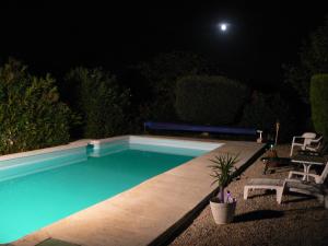 a swimming pool at night with the moon in the background at La Quiétude in Peymeinade