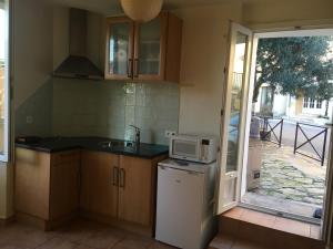 a small kitchen with a sink and a microwave at Coeur de village in Bormes-les-Mimosas +16 photos