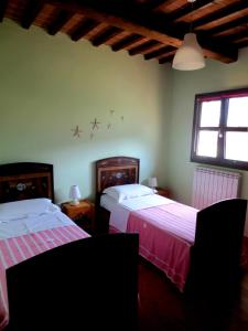 1 dormitorio con 2 camas y ventana en Apartment with privat garden, en Montegabbione