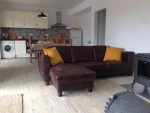a living room with a brown couch and yellow pillows at Wavin' Trees Ericeira in Ericeira