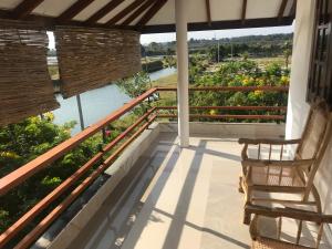 a balcony with two chairs and a view of a river at Anoleth in Kalpitiya