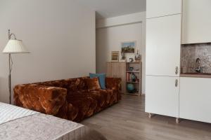 a living room with a brown couch and a white cabinet at M.K. Apartments in Vilnius