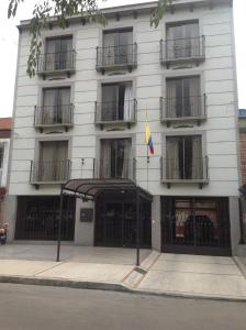 a white building with a flag in front of it at Hotel Castellana Inn in Bogotá