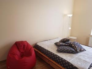 a bedroom with a bed and a red chair at Stylish apartment Riga in Rīga