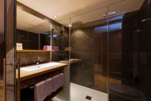 a bathroom with a sink and a shower at Hotel Sandhof in Lech am Arlberg