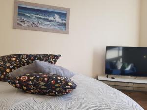 a bedroom with a bed with two pillows and a television at Stylish apartment Riga in Rīga