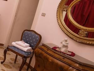 ナポリにあるWELL COME - Museoの椅子と鏡付きの部屋