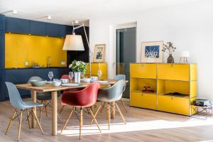 een eetkamer met gele kasten en een tafel en stoelen bij Bellavista-Schenna in Schenna