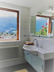 a white bathroom with a sink and a window at Sonnenhaus Sander in Schruns