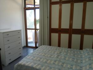 1 dormitorio con 1 cama, vestidor y ventana en Apto confortável de 3 quartos-Cabo Frio, en Cabo Frío