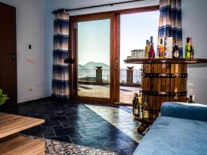 a living room with a glass door and a table with wine bottles at Villa Capri Wonderful View in Massa Lubrense