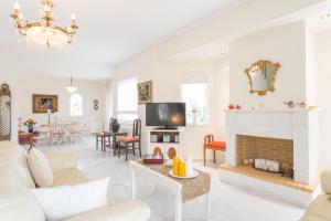 uma sala de estar com mobiliário branco e uma lareira em Lux 3-bedroom Villa - L&L Refuge em Nea Makri