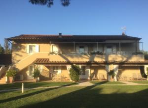 a large yellow house with a large yard at Relais Le Fornacelle in Castagneto Carducci